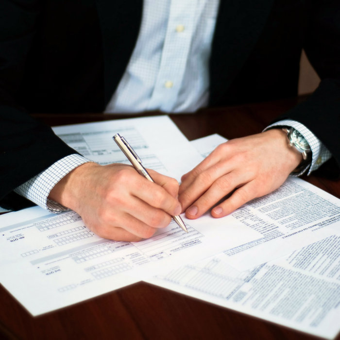 Businessman's hand signing a contract with a pen.